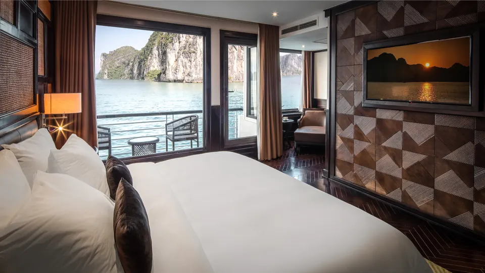 Premium cabin on Ambassador Cruise I with a double bed and a balcony door facing the bay