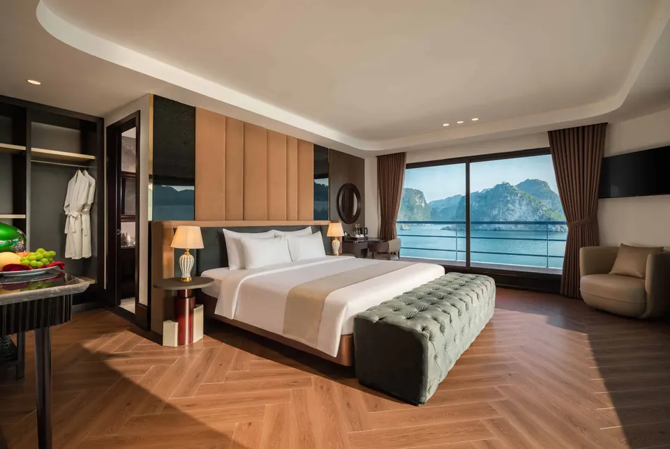 Celina President suite with a large double bed, wooden herringbone floor and floor to ceiling windows facing the bay