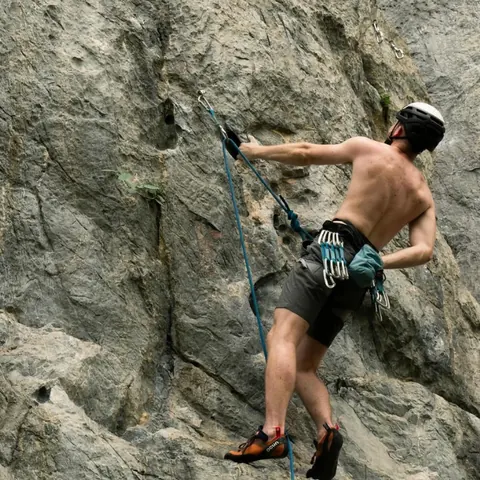 A climber mid-route on a limestone crag