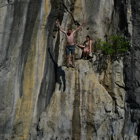 Two climbers on a tall streaked limestone wall