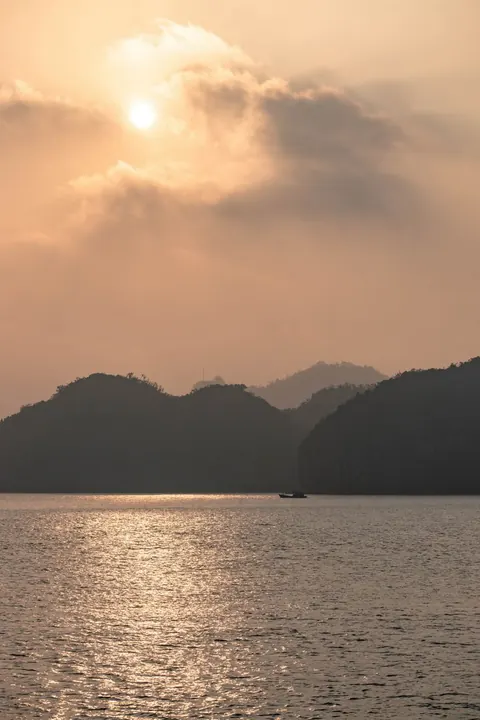 Soft golden light behind the karst islands at dusk