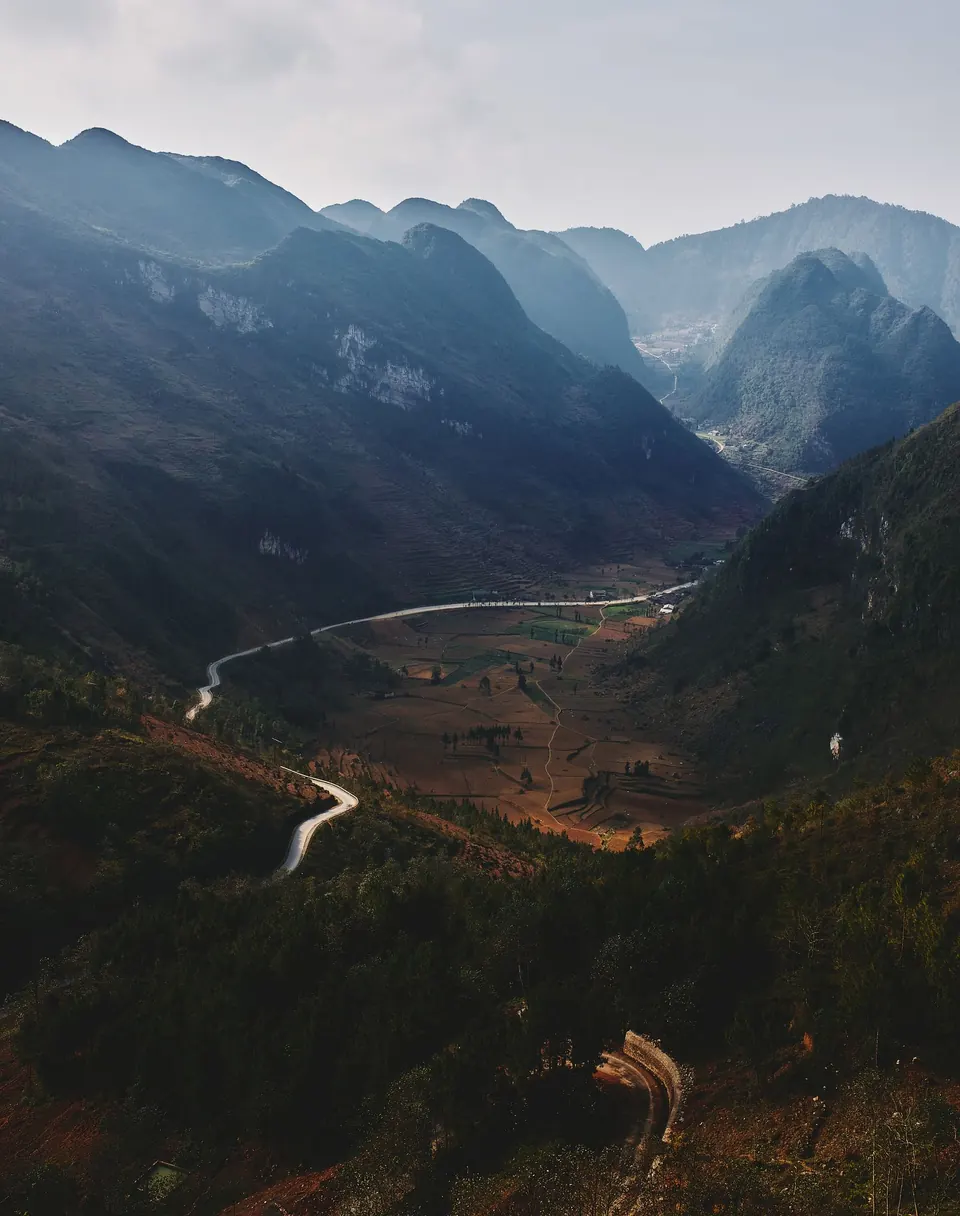 A mountain road winding through a deep valley in Ha Giang