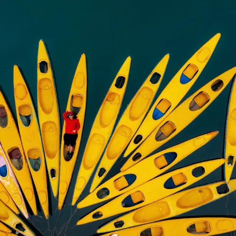 Yellow kayaks seen from above on dark water